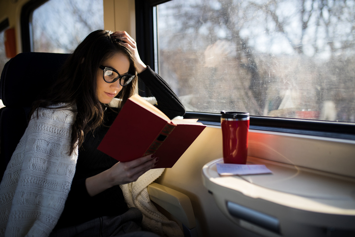 Woman reading while traveling with the train commuter journey sitting