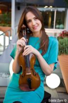 Është diplomuar për violinë në akademinë e Romës. Përzgjidhet në teatrin e “La Scala”-s, ku vijon edhe sot karrierën, si pjesë e orkestrës. Janë një trio e veçantë që operojnë edhe në Lugano të Zvicrës, ndërsa ka fituar të drejtën për të qenë një nga violinistet e trupës së RAI-it. Veshjet: ‘‘COIN’’ Ambienti:‘‘ABA FIFTH’’ 