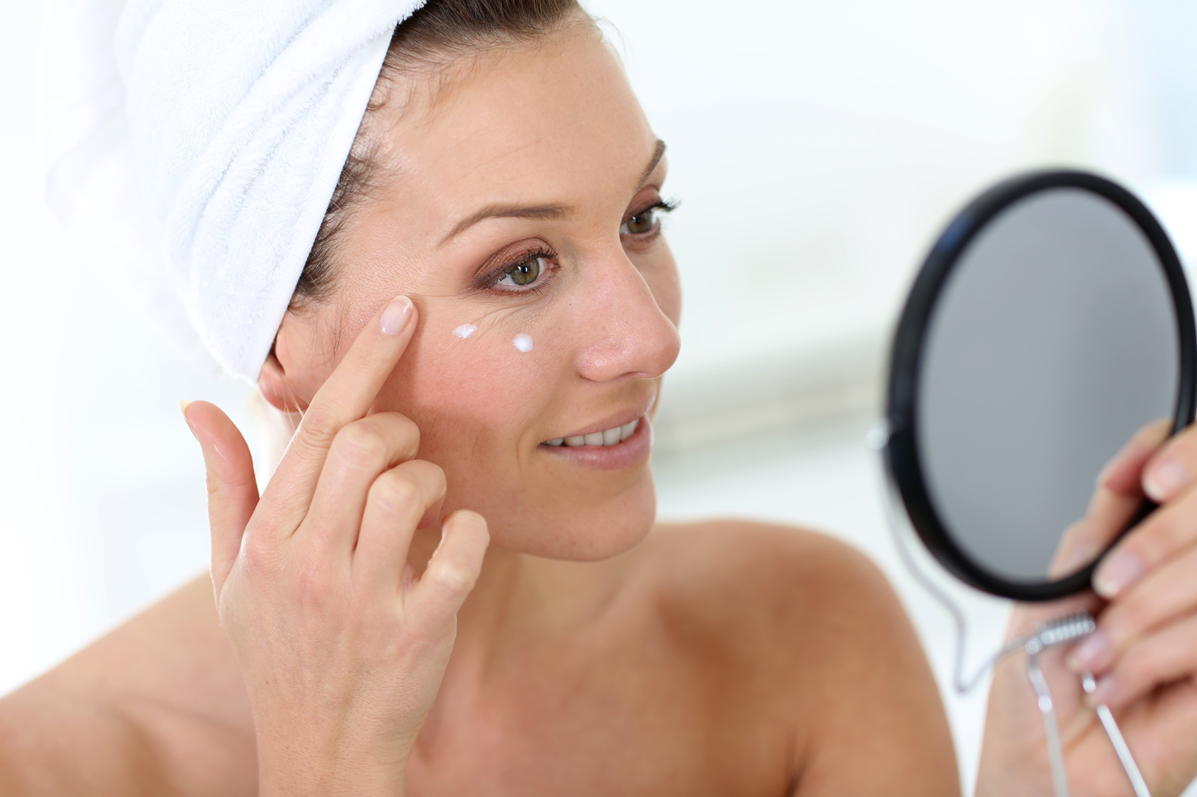 Middle-aged woman in bathroom looking at mirror