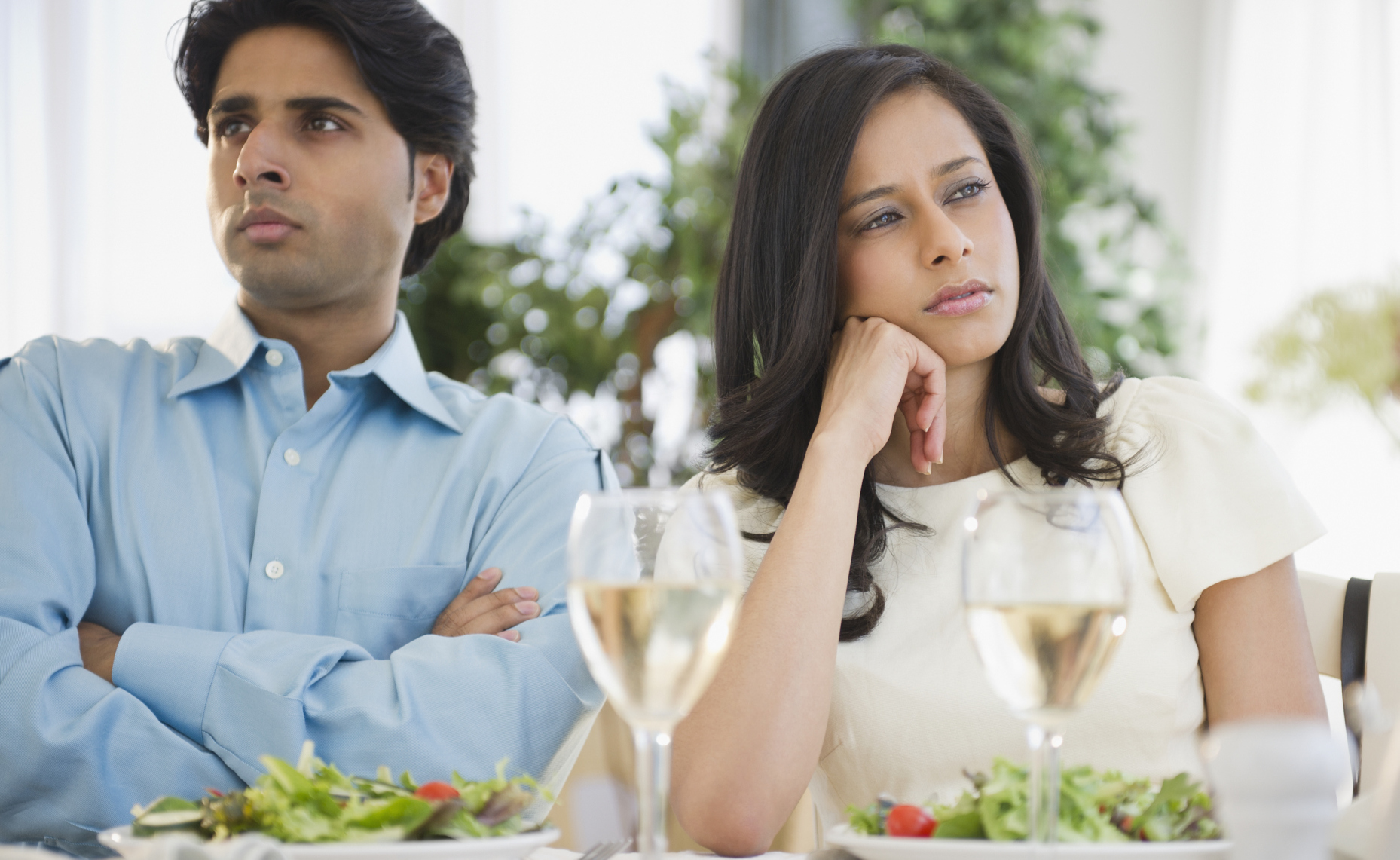 Unhappy mixed race couple dining together