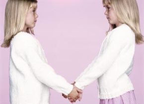 Twin sisters (6-8) holding hands