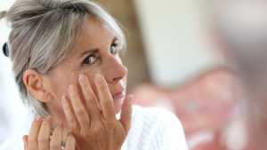 Senior woman applying anti-wrinkles cream