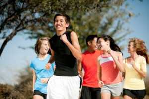 A fit mixed family outside exercising together.