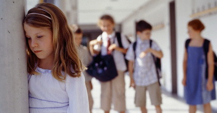 Girls standing apart from others in school