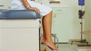 Young woman on table in doctor's office, mid section