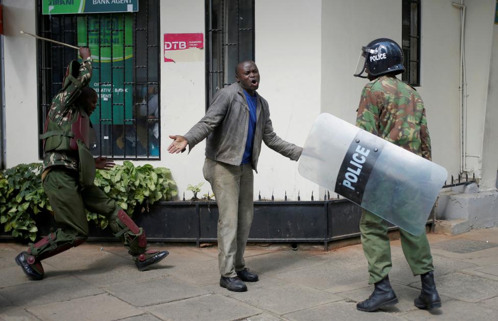 Kenyan policemen beat a protester during clashes in Nairobi, Kenya