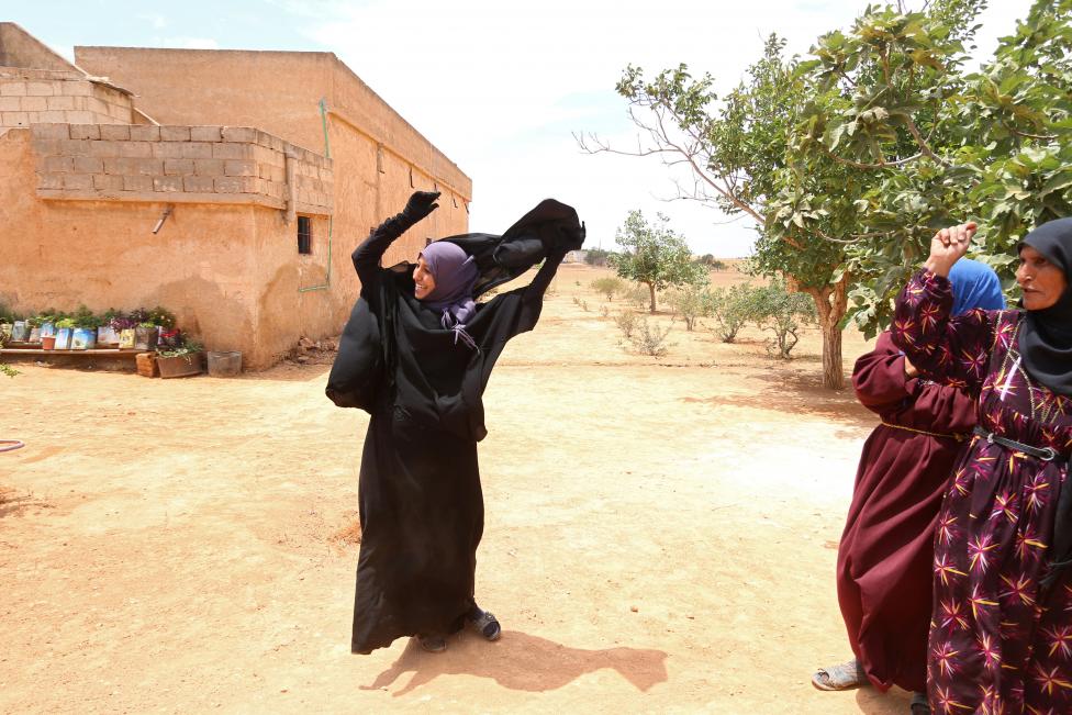 A woman removes a Niqab she was wearing in her village after Syria Democratic Forces (SDF) took control of it, on the outskirts of Manbij city