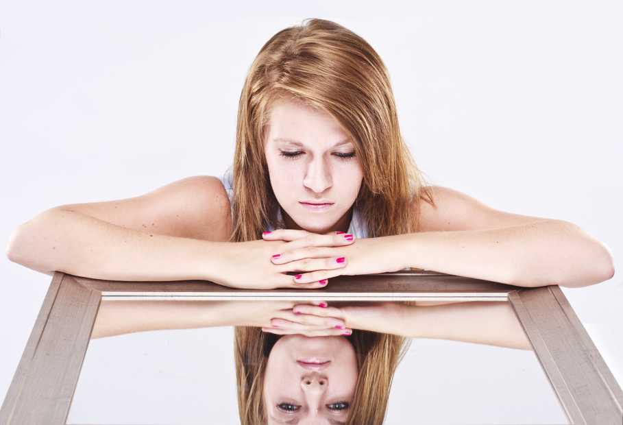 young woman looking into a mirror