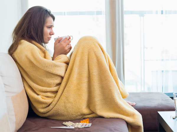 Side view of sick woman having coffee