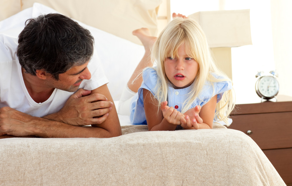 Little girl talking seriously with her father at home