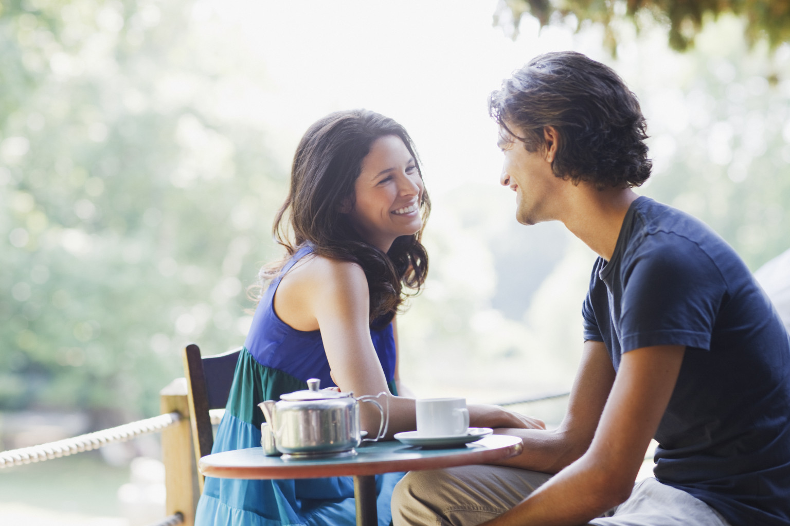 Smiling couple having tea outdoors