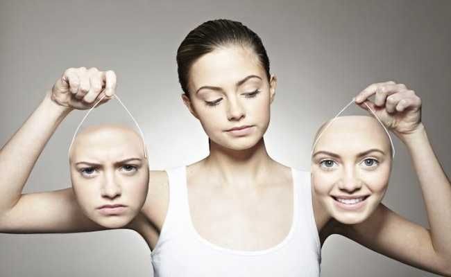 Young woman holding emotive masks