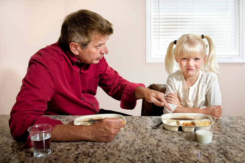 A little girl refuses to eat what Dad has cooked for dinner.