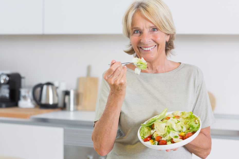 Smiling woman eating salad