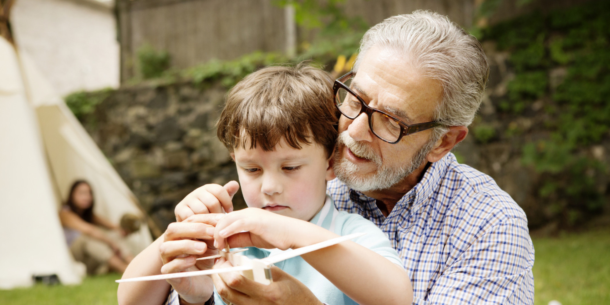 Grandfather and Boy Playing with Model Airplane