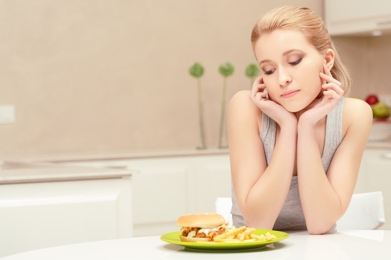 young_woman_eating_fast_food_meal_alone