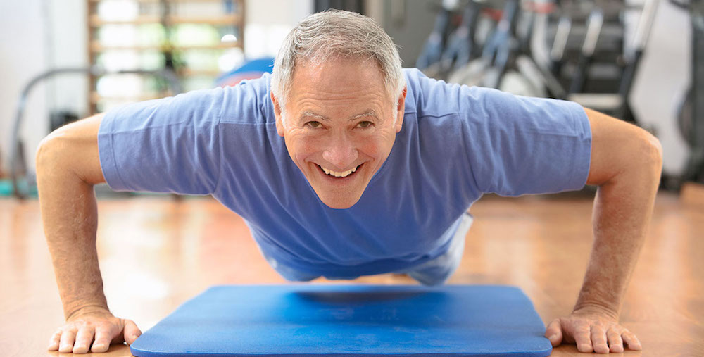 Senior Man Doing Press Ups In Gym