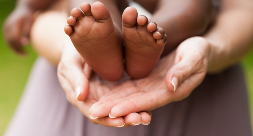 Baby's feet on mothers hands. Horizontal Shot.