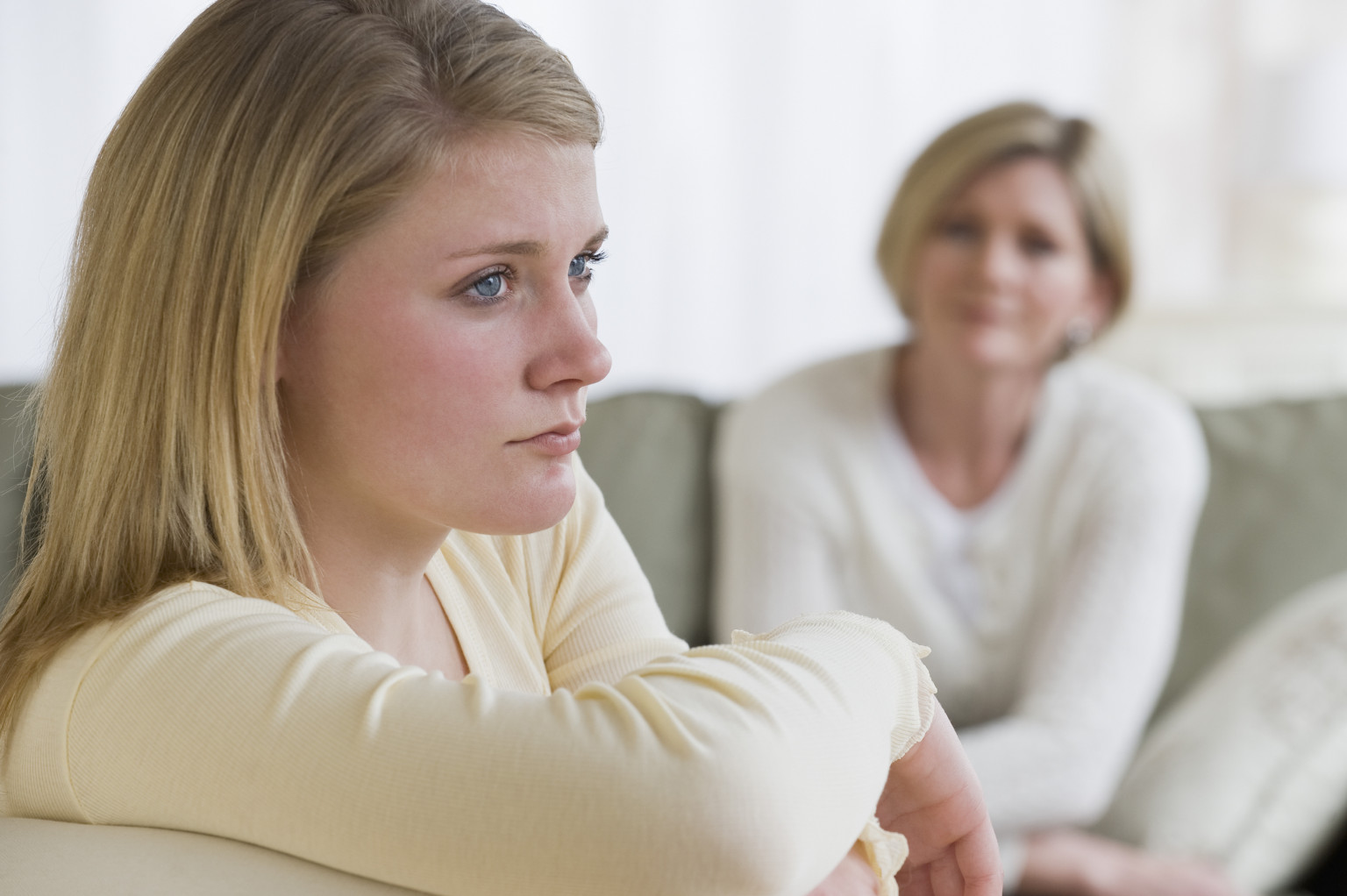 Teenaged girl looking away from mother