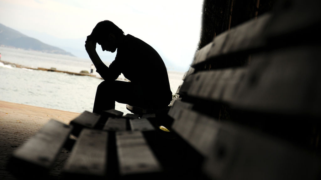 Young man sitting looking upset