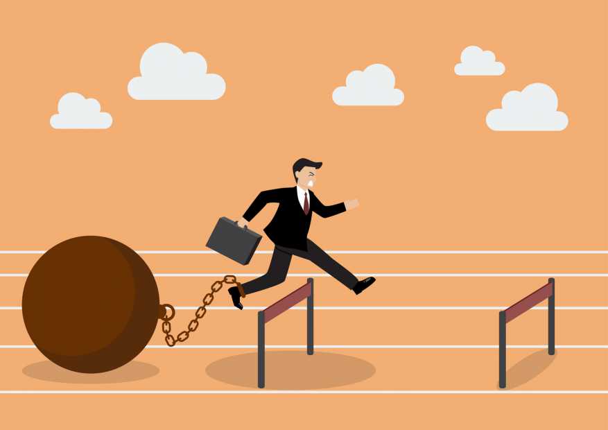 Businessman jumping over hurdle with the weight. Business concept