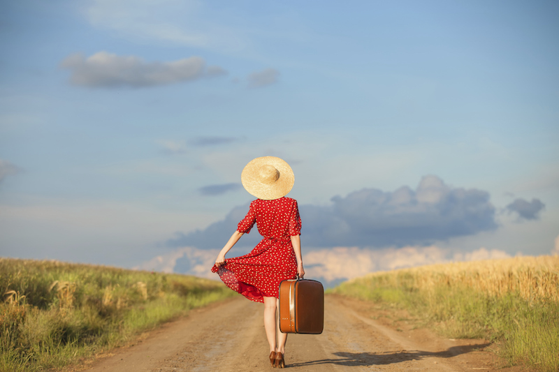 Redhead girl with suitcase at outdoor.