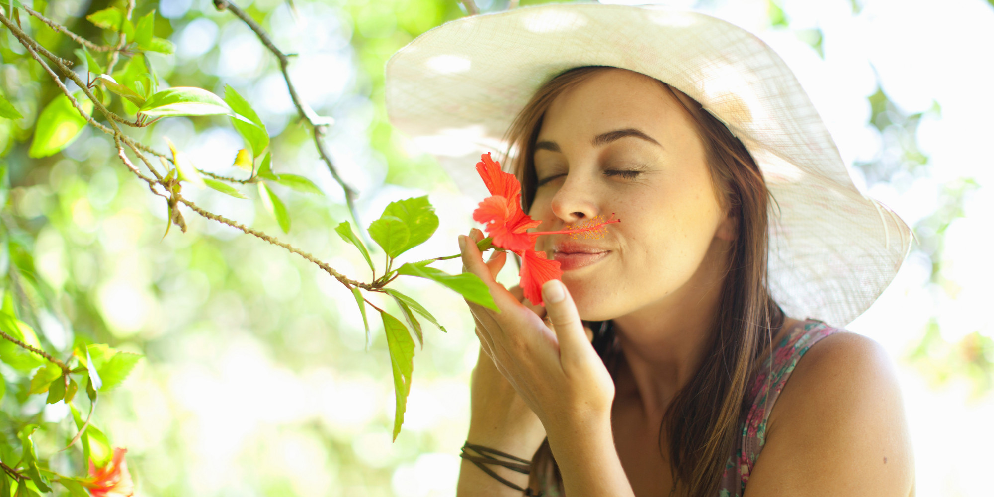 Woman smelling flower in park