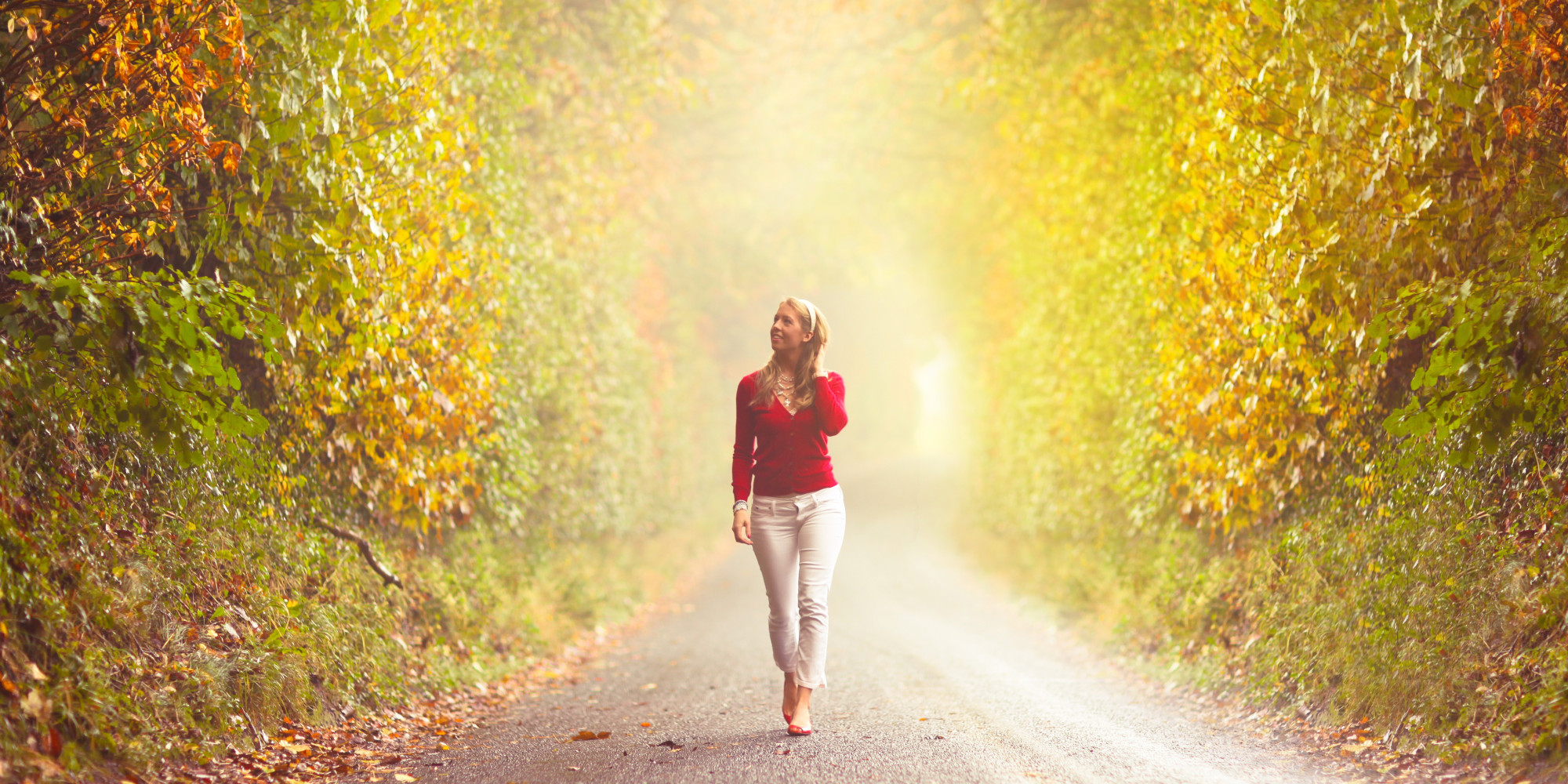 Girl walking in country road in the autumn fog