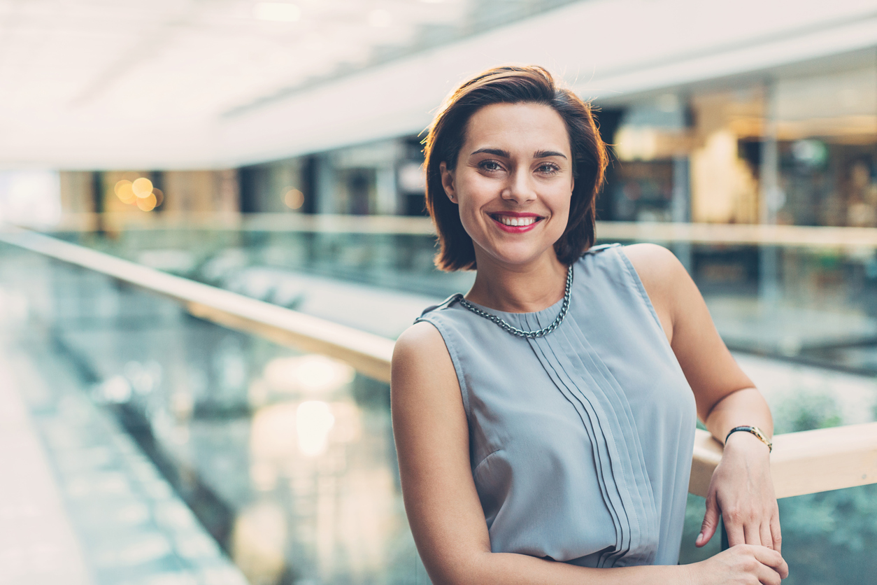 Stylish businesswoman standing in business environment, with copy space.