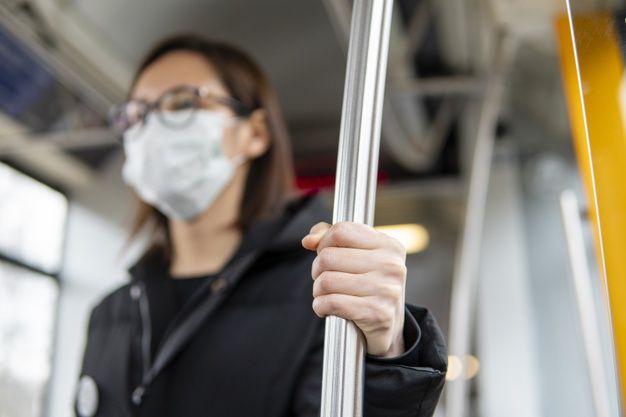 download-portrait-of-young-woman-using-public-transport-with-mask-for-free