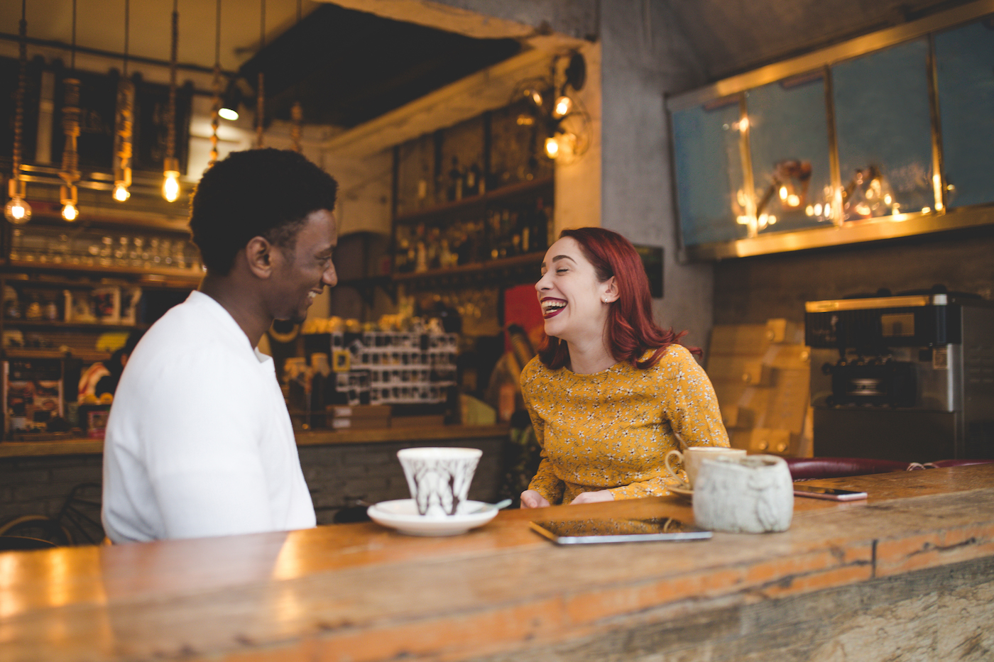 Beautiful couple sitting in the coffee shop and drinking coffee, smiling and having fun