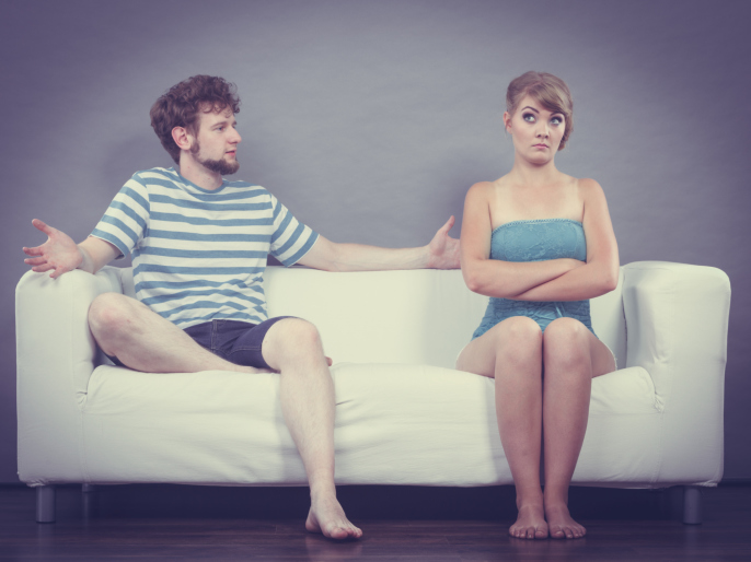 Man and woman in disagreement sitting on sofa