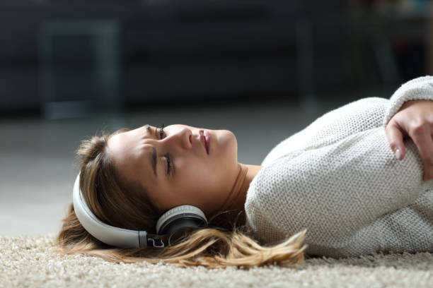 Sad woman listening to music on the floor