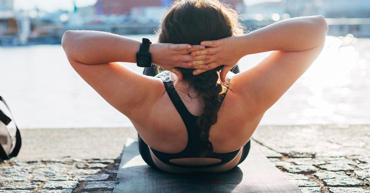 woman-exercising-outdoors-situps-yoga-hiit-1200x628-facebook