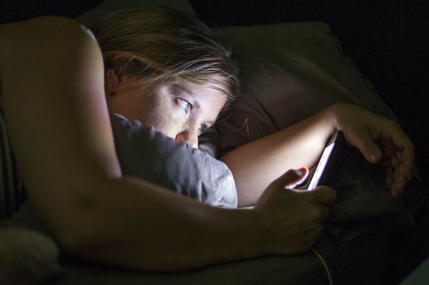 woman-using-a-mobile-phone-in-bed